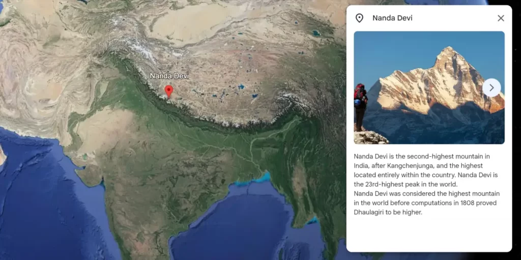 A Google Maps image of Mount Nanda Devi, the second-highest mountain in India and the 23rd-highest mountain in the world. The mountain is located in the Garhwal Himalayas of India. The summit is covered in snow and ice, and the surrounding peaks are shrouded in clouds. The image shows the mountain from a distance, and the surrounding area is sparsely populated.

Description:

This alt text includes the following information:

The name of the mountain
The height of the mountain
The location of the mountain
A description of the mountain, including its physical features and surroundings
The type of image (Google Maps)